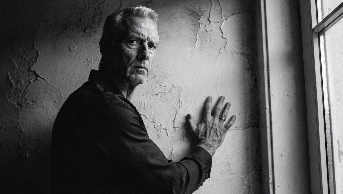 Man projecting charisma through body language near a window
