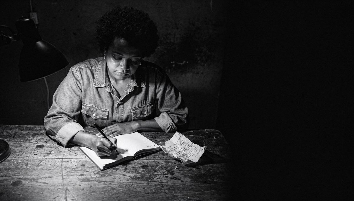 Woman tracking feedback progress in a notebook, 60-day plan