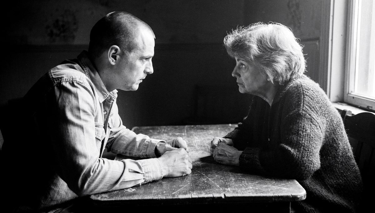 Two colleagues in tense sandwich feedback method conversation across table