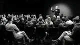 Eamon Blackthorn presenting his book Say It Right Every Time to a seated audience in a darkened venue